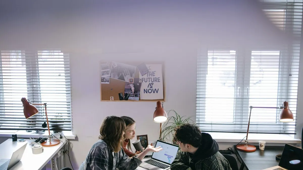 Equipo de trabajo probando distintas herramientas de IA en una reunión con portátil