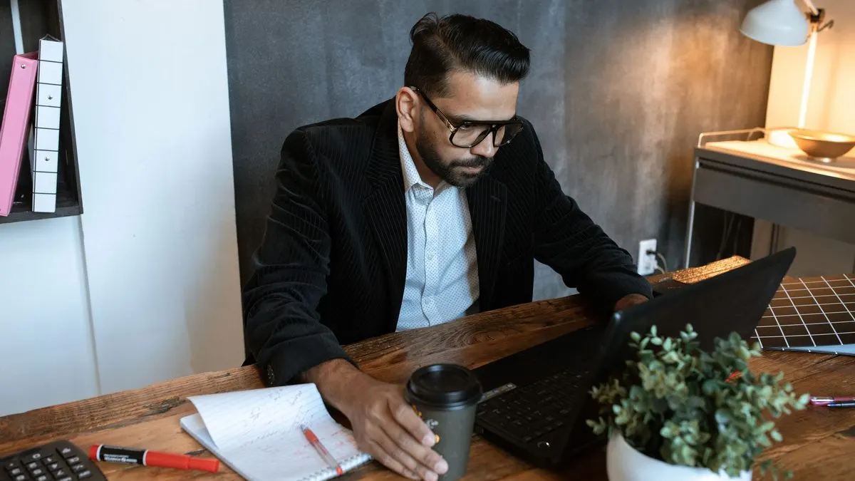 Autónomo trabajando con su ordenador portátil revisando tareas de su negocio