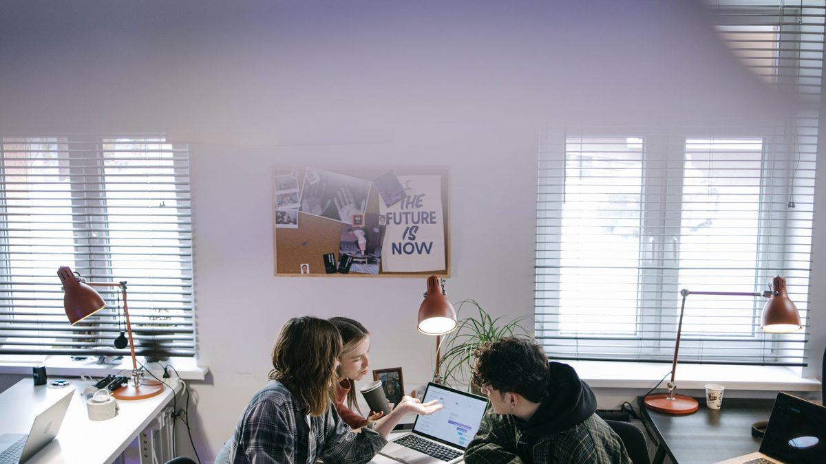Equipo de trabajo probando distintas herramientas de IA en una reunión con portátil
