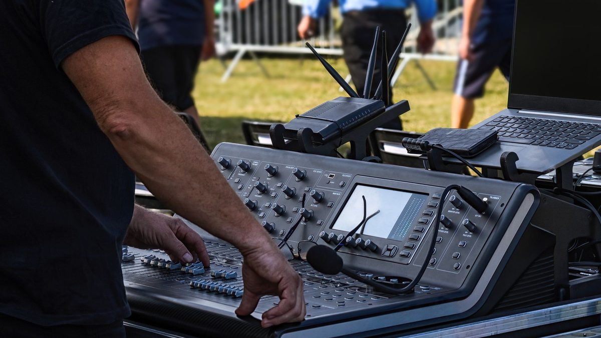 Técnico de sonido trabajando en una mesa de mezclas durante un evento en directo