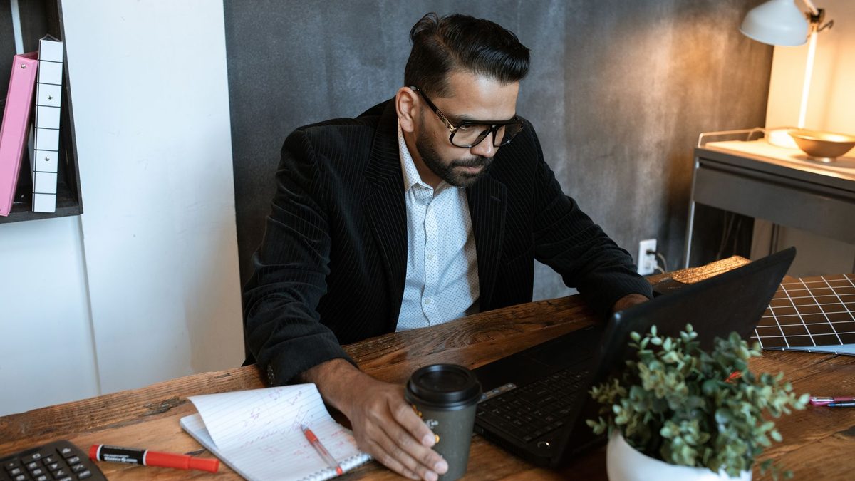 Autónomo trabajando con su ordenador portátil revisando tareas de su negocio