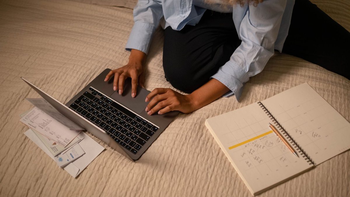 Persona organizando su trabajo con portátil y notas