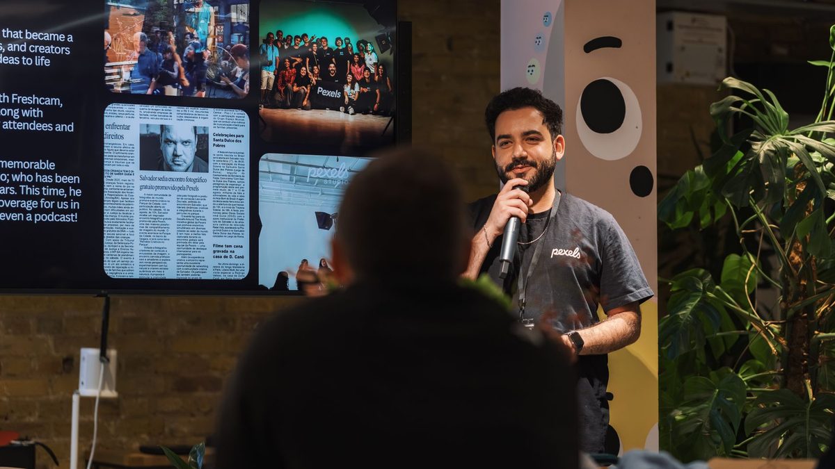 Ponente con micrófono dirigiéndose al público en un evento presencial